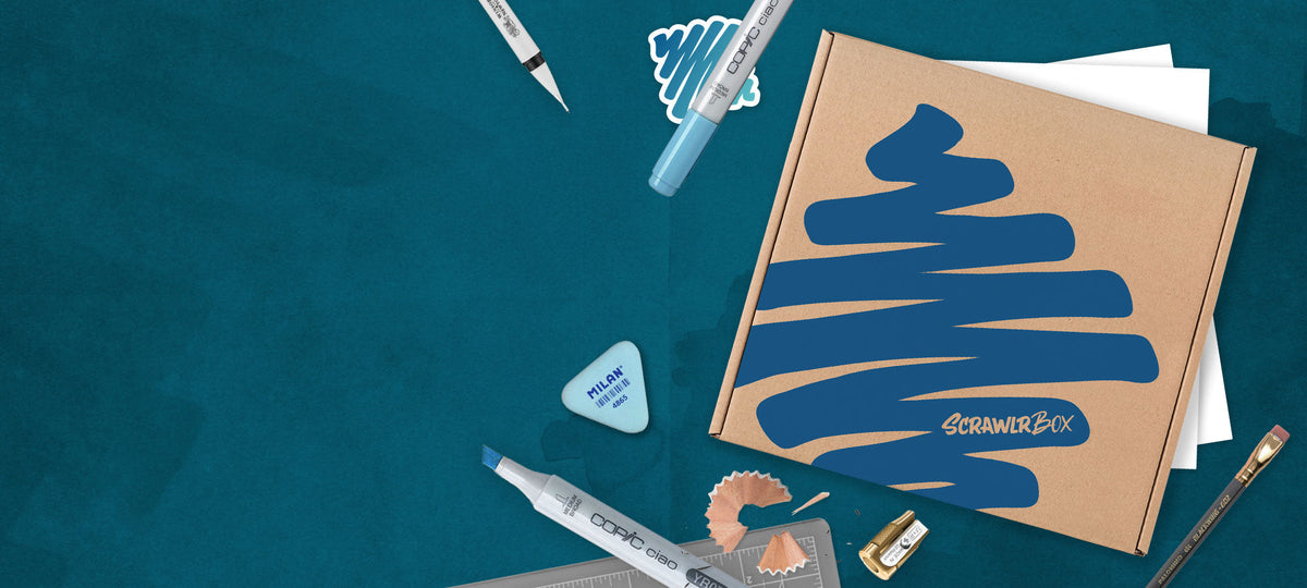ScrawlrBox with drawing materials on a blue-green creative desk